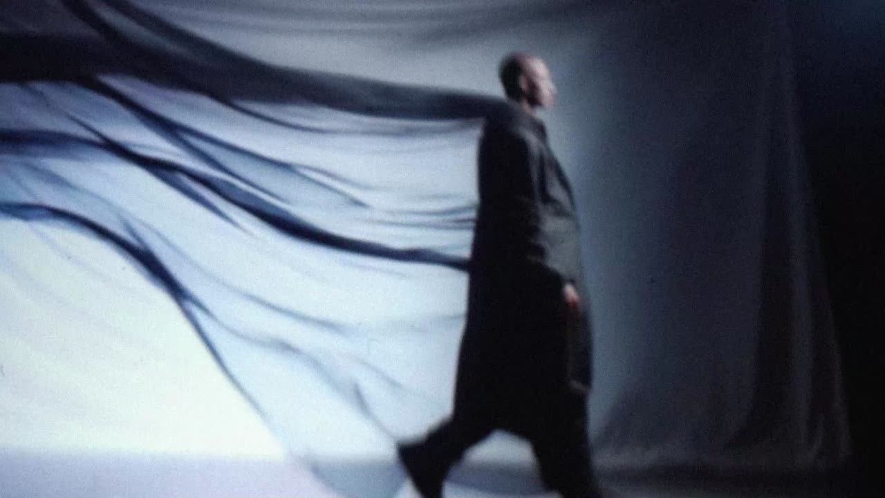 Dancer moving with a black veil against a white backdrop